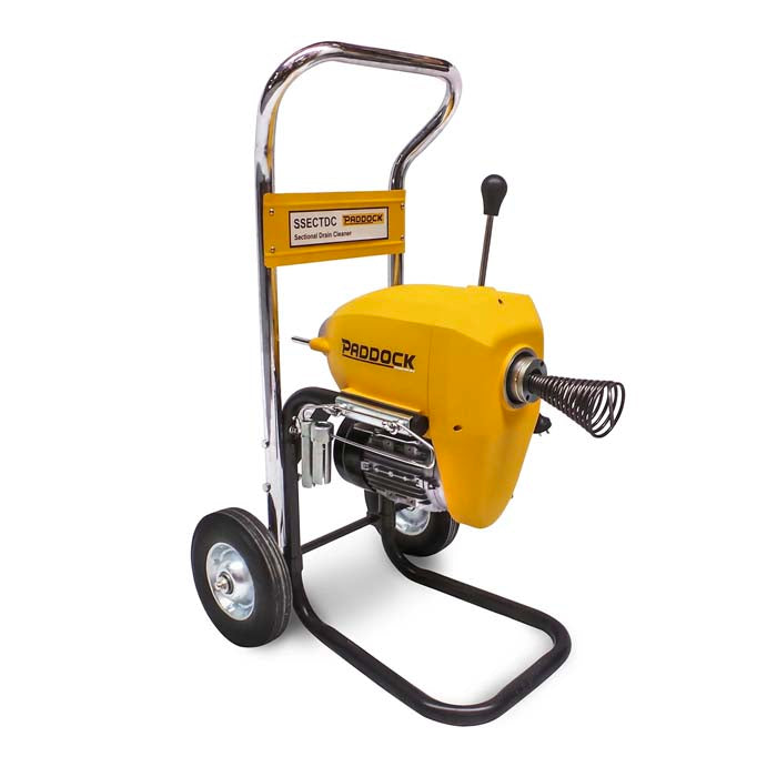 A yellow and black portable drain cleaning machine with wheels, a steel frame, a handle, and a coiled cable on the front. The machine is labeled Padock.