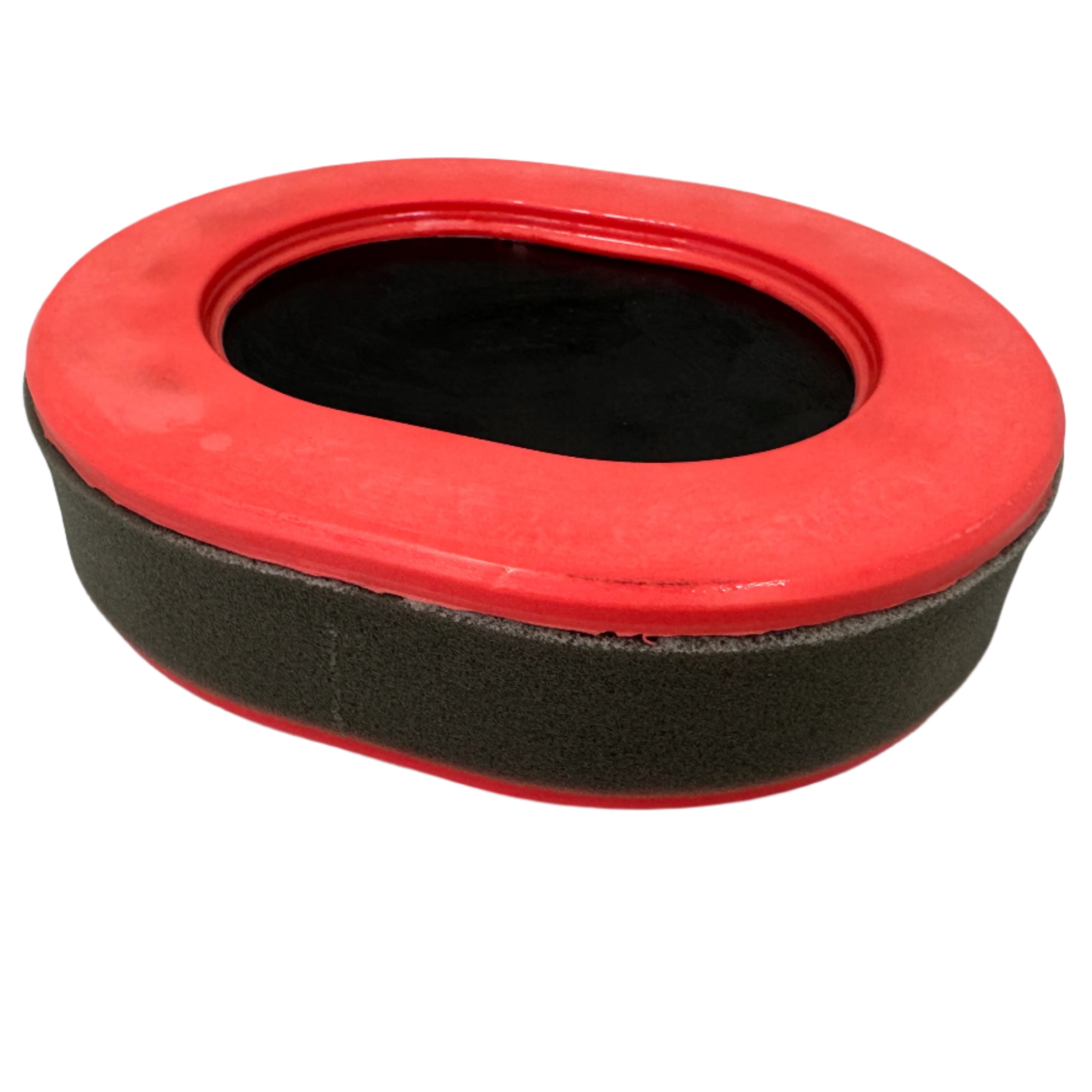 A gray and red oval foam buffing pad, similar to something in the Paddock series, is utilized for polishing surfaces and rests on a light gray floor.