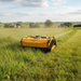 Paddock Yellow radio controlled mower in a field with a scenic background
