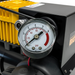 A close-up of a Scintex Sherpa 4x4 BIG AIR Pressure Gauge attached to a black and yellow air compressor, needle at 60 psi. Suited for 12V and 24V setups. White background.