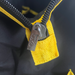 Close-up of a metal zipper on black fabric with yellow trim from the Sherpa 4x4 ‘BIG V4’ Quad-Air Bundle – (400 L/min) 4-Tyre Inflation System carrying case. The zipper pull has “SKS” and “ZIPPER” engraved on it, and the stitching along the yellow fabric is clearly visible.
