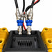 Close-up of two blue and silver industrial connectors fastened to thick black cables, mounted on a yellow and black mechanical unit with visible metal bolts and ridged components—featured as part of the Sherpa 4x4 ‘BIG V4’ Quad-Air Upgrade Kit – 4-Tyre Inflation System from Sherpa 4x4.