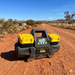 The Sherpa 4x4 'BIG V4' Air Compressor (400 L/min) & Digital Tyre Deflator Bundle is shown on a red dirt road in a rural landscape—perfect for off-road tyre inflation amid dry grass and hills under a blue sky.