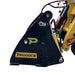 Close-up of a black and yellow Paddock-branded hydraulic attachment on heavy machinery, highlighting metal parts and hoses—designed for use with Paddock 4in1 Buckets and other compatible equipment.