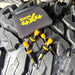 Four Sherpa 4x4 Tyre Deflators and a black case sit on the tread of a large, wet off-road tire—fast, reliable tyre deflation tools from Sherpa 4x4, perfect for any off-road adventure.