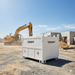 A Paddock Bunded Diesel Tank by Paddock sits on gravel at a construction site, with an excavator and a partly built structure visible under a clear blue sky.