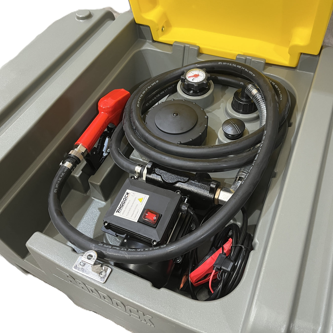 A Paddock Ute & Trailer Mount Diesel Tank with its yellow lid open displays hoses, a red fuel nozzle, gauge, control box, and power cables neatly organized inside the gray portable container.
