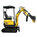 A compact yellow Paddock Excavator Series 17 with black cab and tracks is parked indoors against a concrete wall, its articulated arm and bucket—part of the 6 Attachments Bundle—extended forward.