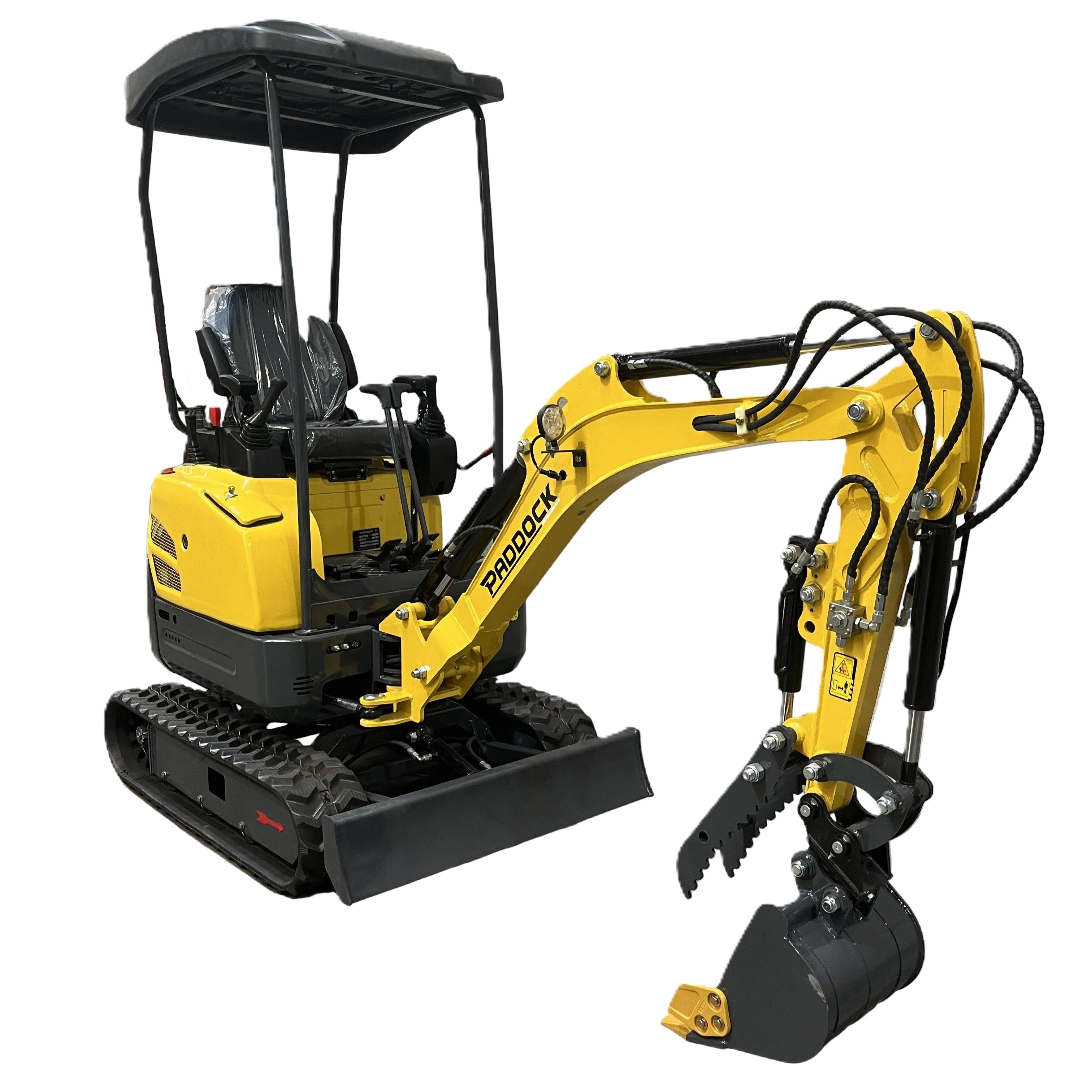 A compact yellow and black Paddock Excavator Series 17 with canopy, displaying the Paddock logo on its arm, is parked indoors on a concrete floor near a gray wall; includes 6 attachments bundle.