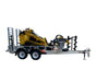 A Paddock Mini Loader is secured on a Paddock Mini Loader & Excavator Alloy Equipment Trailer with ramps, along with an auger and tools. The setup highlights the versatility of Paddock alloy trailers, all isolated on a white background.