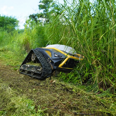 The Paddock™ Remote Controlled Mower 16HP - 740mm, by Paddock, features a powerful 4-stroke petrol engine and a durable track drive system to efficiently cut grass even near tall vegetation on sunny days, blending effortlessly into its lush green surroundings.