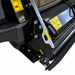 Close-up of a black industrial machine part from the Paddock™ PTO Offset Verge Flail Mower by Paddock, featuring bolts and yellow caution labels with warning symbols, photographed on a white background.