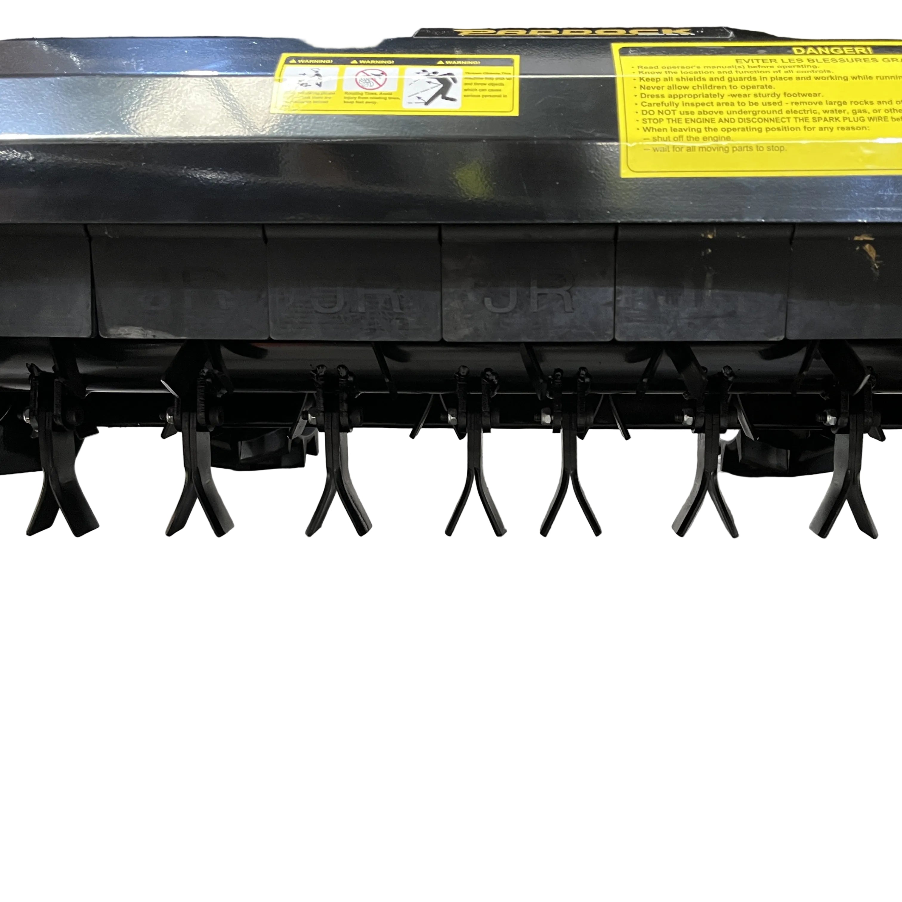 Close-up of the Paddock Walk Behind Flail Mower 12HP - 900mm shows its black metal blades beneath, arranged in a row above concrete. Yellow warning labels mark this Paddock mower, built for efficient vegetation control.