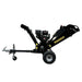 A black Paddock Wood Chipper Mulcher by Paddock is placed indoors on a concrete floor against a gray wall. It features large wheels, a chute, powerful petrol engine, and a tow bar for easy transport.