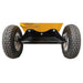 The black axle and two pneumatic tires of a yellow Paddock™ Wood Chipper Shredder 75mm.
