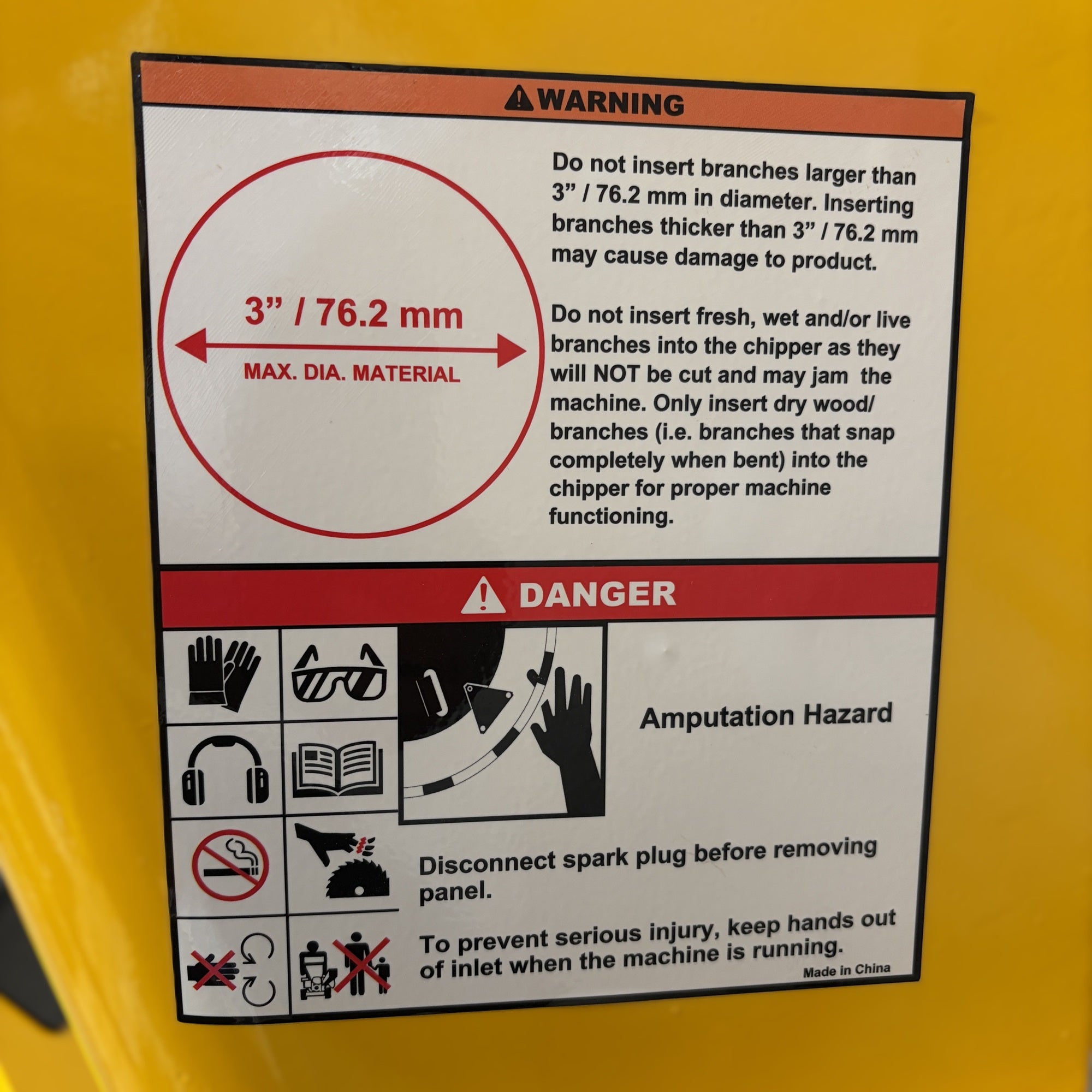 A safety warning label on a Paddock™ Wood Chipper Shredder 75mm, showing a 3-inch maximum branch diameter, instructions to use only dry wood, and danger icons for amputation and maintenance hazards.