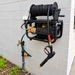 Paddock™ 1,450 PSI Wall Mountable Pressure Washer with Hose Reel mounted to a wall and connected to an outdoor spigot for efficient car detailing.