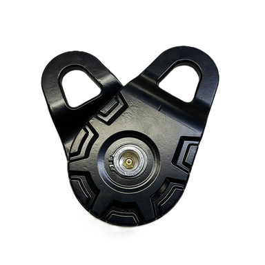 The Sherpa 4x4 Snatch Block is a black metal winch accessory for 4x4 recovery, featuring two top mounting holes and a central rotating wheel, pictured against a white background.