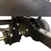 Close-up of the adjustable metal hitch mount and gearbox on a Paddock Seed & Fertiliser Spreader (Heavy Duty), with a tire in the background.