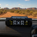 The Sherpa 4x4 Tyre Pressure Monitoring System (TPMS) from Sherpa 4x4 shows the pressure and temperature of all four tires on your car’s dashboard, with a dirt road and mesas visible through the windshield in the background.