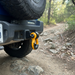 A close-up shows a Sherpa 4x4 Alloy Recovery Hitch - Black, a rugged Sherpa 4x4 accessory, attached to the hitch receiver of an off-road vehicle on a rocky trail surrounded by trees.