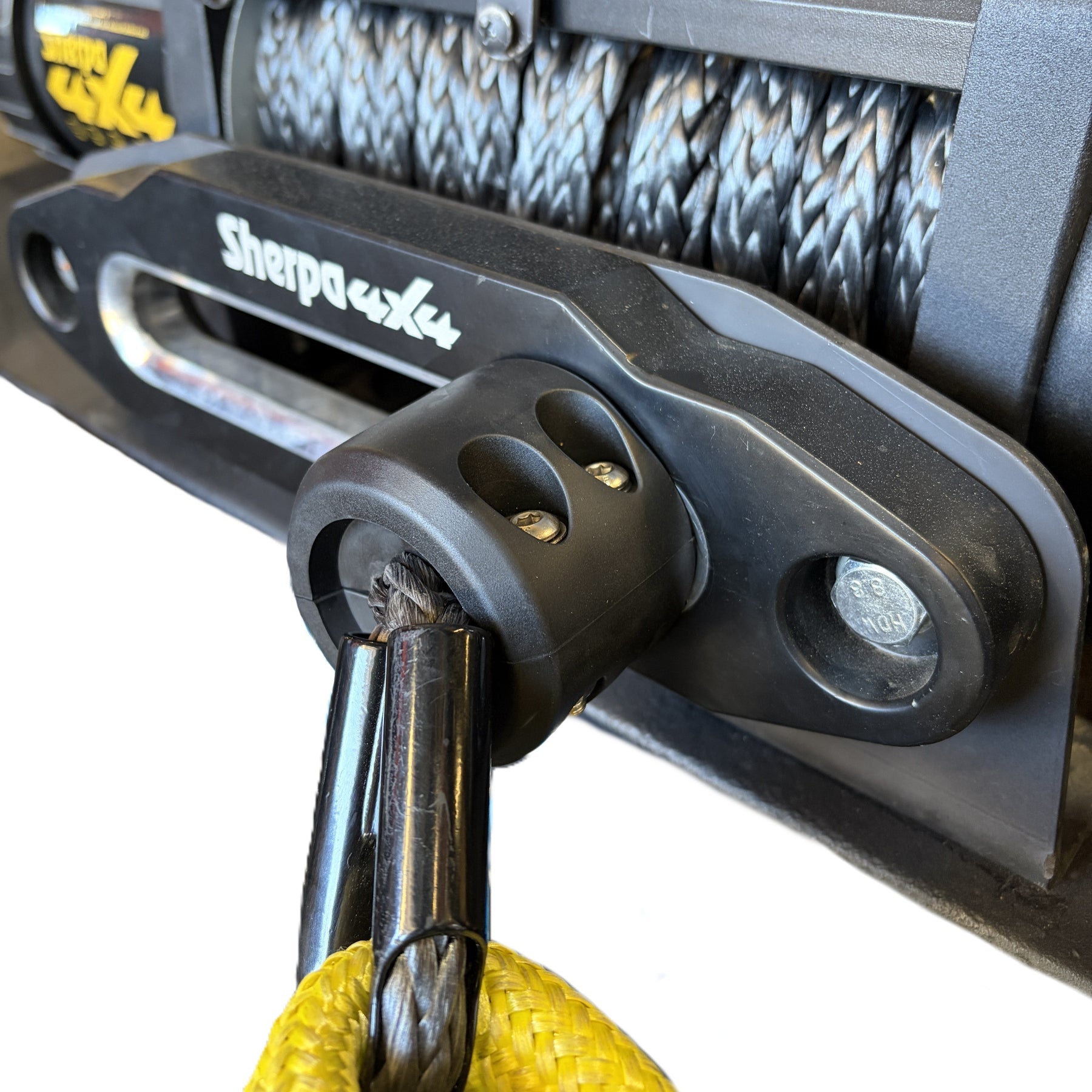 Black rubber Sherpa 4x4 Winch Cable Stopper / Up to 12.7mm mounted on a fairlead with a yellow strap attached, serving as a durable winch rope protector.