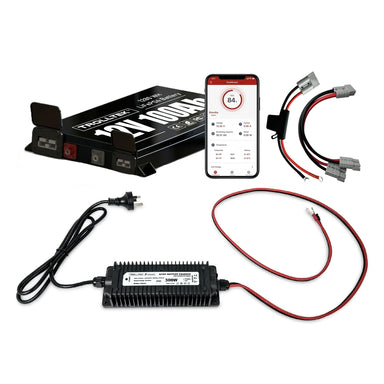 On a white background, the Trolltek™ 12V LiFePO4 Lithium Slimline Battery AC Bundle – Charge From 240V Power (AC) by Trolltek is displayed alongside a smartphone showing battery stats, app cables, charger, and power cord.