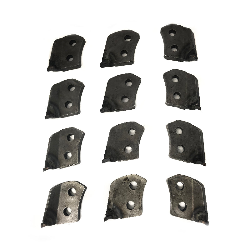 Twelve identical Scintex Stump Grinder Cutting Teeth, each black and metal with two holes, are arranged in a grid pattern on a white background. The teeth appear worn and slightly angled.