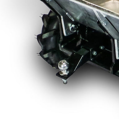 Close-up of a rugged black tire with deep treads on a Paddock Power Barrow, featuring a shiny Tow Ball Hitch attached to the metal frame below.