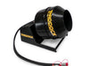 A black Scintex Paddock Cement Mixer Attachment with a hose and hydraulic couplings, mounted on a base. It features yellow branding text on its surface, similar to the robust functionality of a mini loader cement mixer.